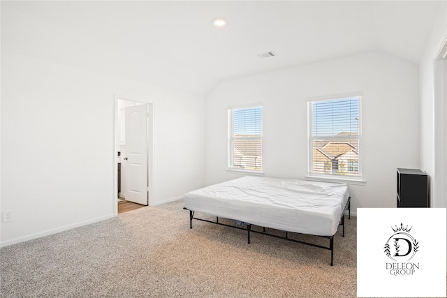 carpeted bedroom with lofted ceiling