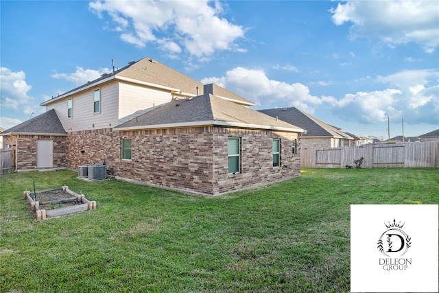 rear view of house with cooling unit and a yard