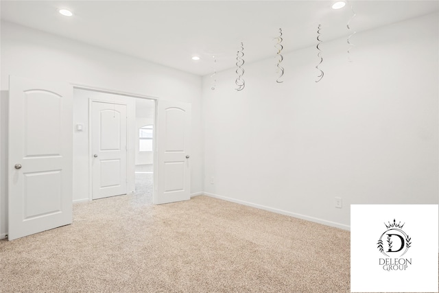 unfurnished room featuring light colored carpet