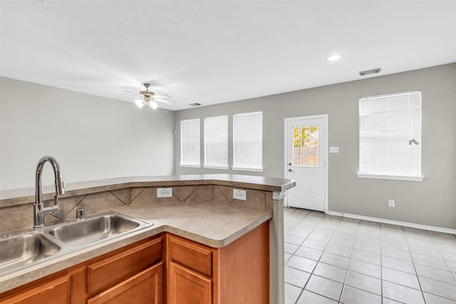 kitchen with sink, light tile patterned floors, and ceiling fan