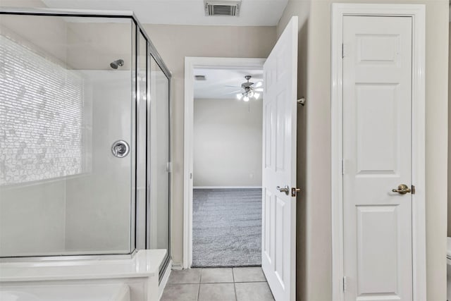 bathroom featuring tile patterned flooring, toilet, ceiling fan, and a shower with shower door