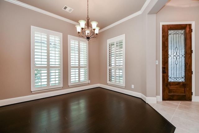 foyer featuring ornamental molding, light hardwood / wood-style floors, and a chandelier