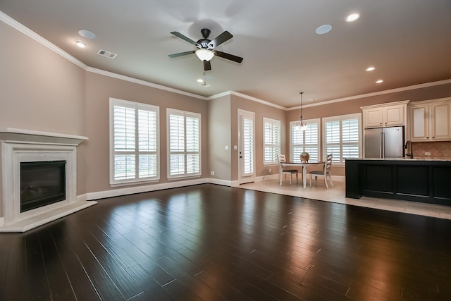 living room with wood-type flooring, sink, ceiling fan, and crown molding