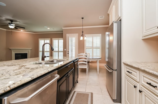 kitchen featuring sink, light stone counters, light tile patterned floors, ornamental molding, and appliances with stainless steel finishes