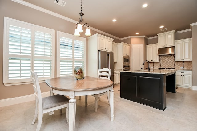 kitchen featuring appliances with stainless steel finishes, pendant lighting, crown molding, light stone countertops, and a center island with sink