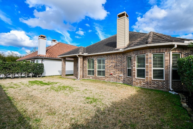 rear view of house featuring a yard