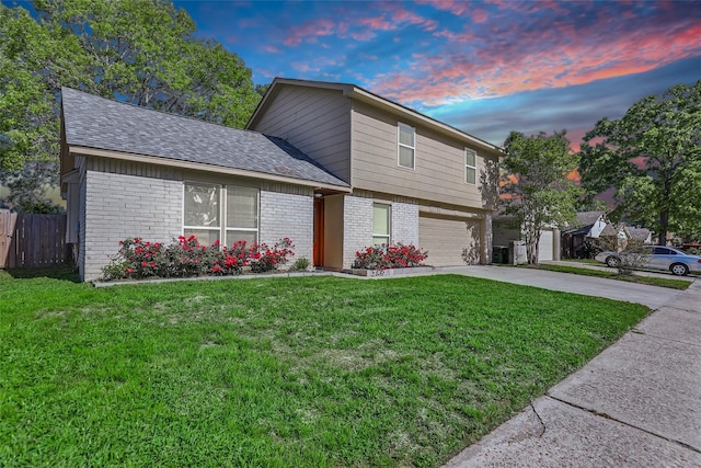 front of property with a garage and a yard