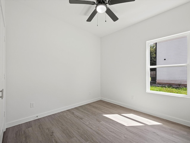 empty room with ceiling fan, light hardwood / wood-style floors, and a healthy amount of sunlight