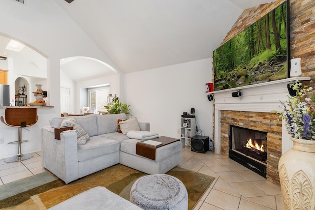 living room with light tile patterned floors and high vaulted ceiling