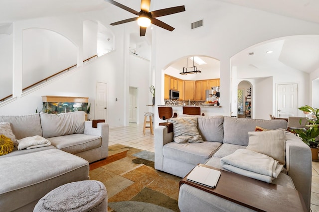 living room with light tile patterned floors, high vaulted ceiling, and ceiling fan