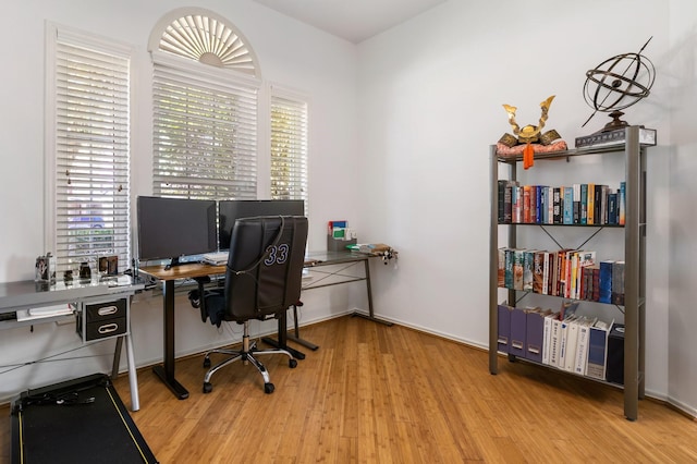 home office with light hardwood / wood-style flooring