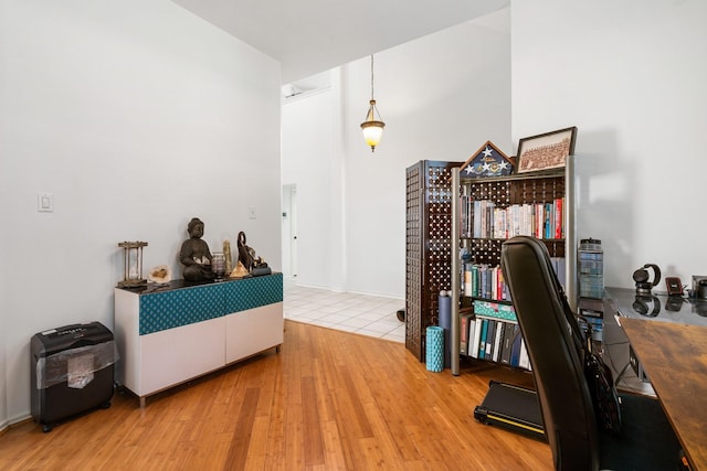 office area featuring wood-type flooring and a high ceiling