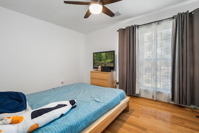 bedroom featuring multiple windows, ceiling fan, and light hardwood / wood-style floors