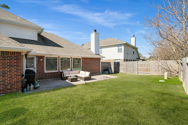 rear view of property featuring outdoor lounge area, a yard, and a patio area