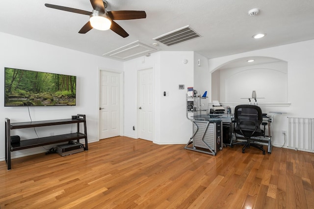 office space featuring hardwood / wood-style flooring, ceiling fan, and radiator heating unit