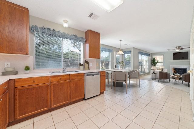 kitchen with decorative light fixtures, sink, stainless steel dishwasher, light tile patterned floors, and ceiling fan