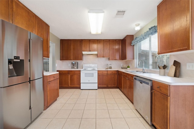 kitchen with sink, light tile patterned floors, and stainless steel appliances