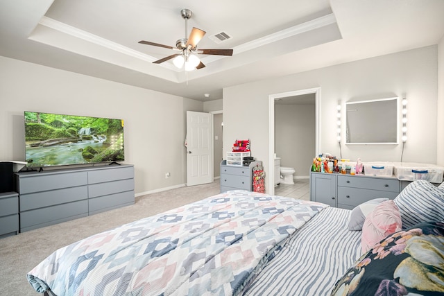 bedroom with crown molding, ceiling fan, connected bathroom, light colored carpet, and a raised ceiling