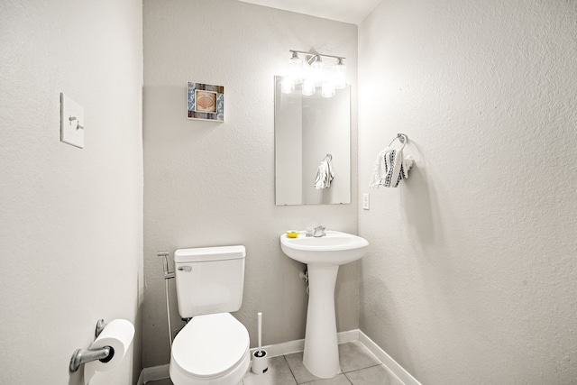 bathroom featuring sink, toilet, and tile patterned flooring