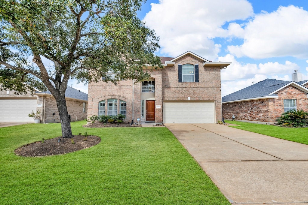 front facade featuring a garage and a front lawn