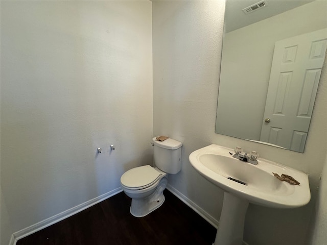 bathroom with hardwood / wood-style flooring and toilet