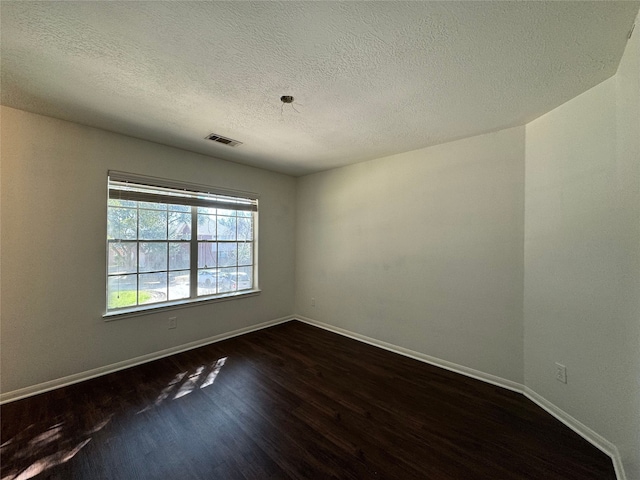 unfurnished room featuring dark hardwood / wood-style flooring and a textured ceiling