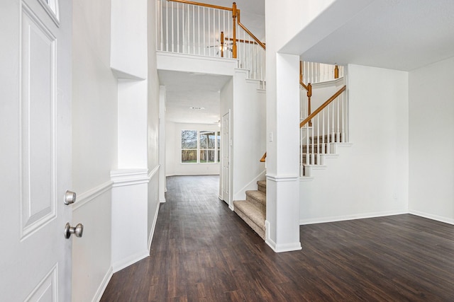 interior space with stairs, baseboards, and dark wood-style flooring