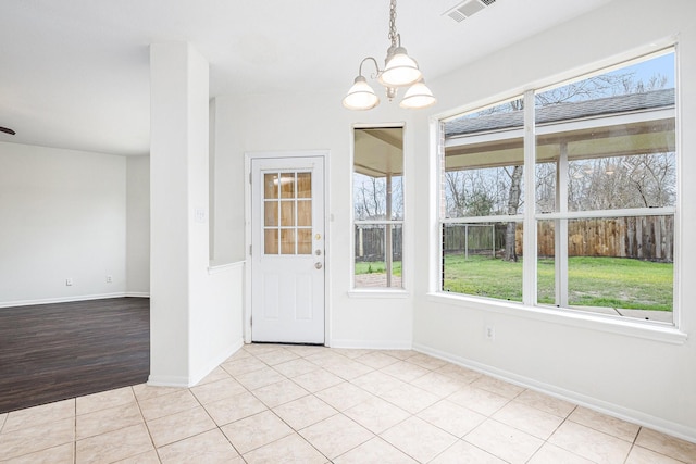 unfurnished dining area featuring visible vents, a notable chandelier, baseboards, and light tile patterned flooring