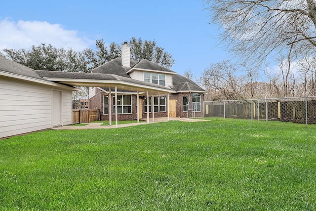 rear view of house featuring a patio area, brick siding, and a yard