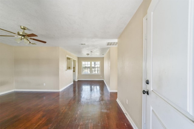 interior space with ceiling fan, dark wood-type flooring, and a textured ceiling