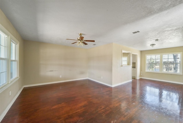 spare room featuring ceiling fan, a textured ceiling, and dark hardwood / wood-style flooring