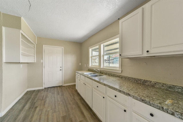 kitchen with white cabinetry, sink, dark hardwood / wood-style floors, and a textured ceiling