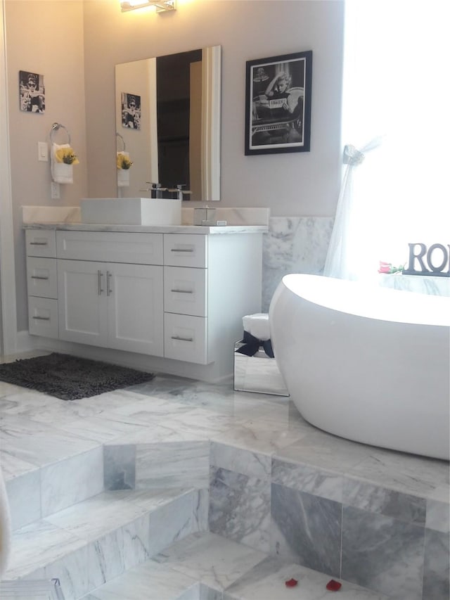 bathroom with vanity, tile walls, and a washtub