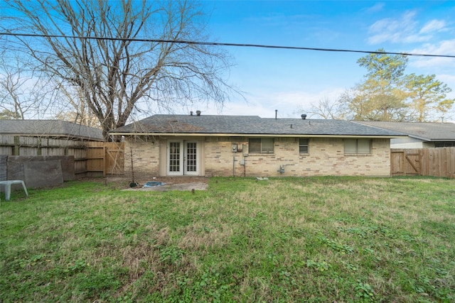 back of property with a lawn and french doors