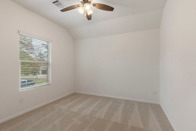 carpeted spare room featuring ceiling fan and vaulted ceiling