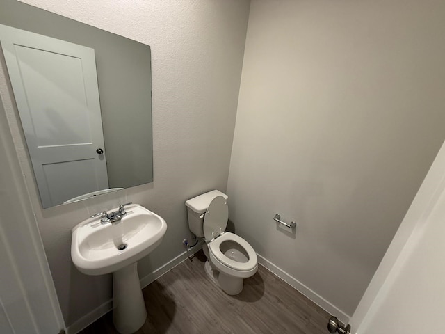 bathroom featuring hardwood / wood-style flooring and toilet