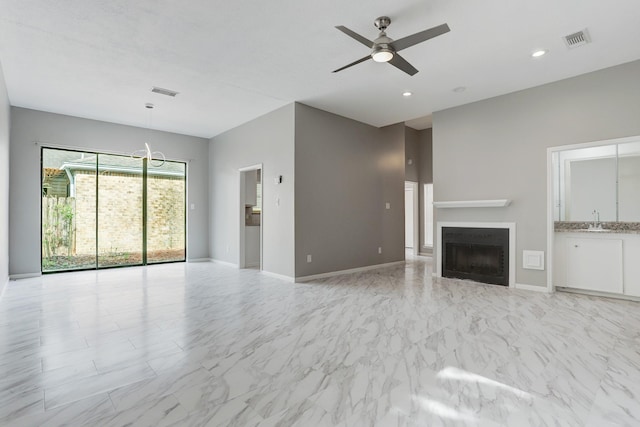 unfurnished living room with ceiling fan and sink