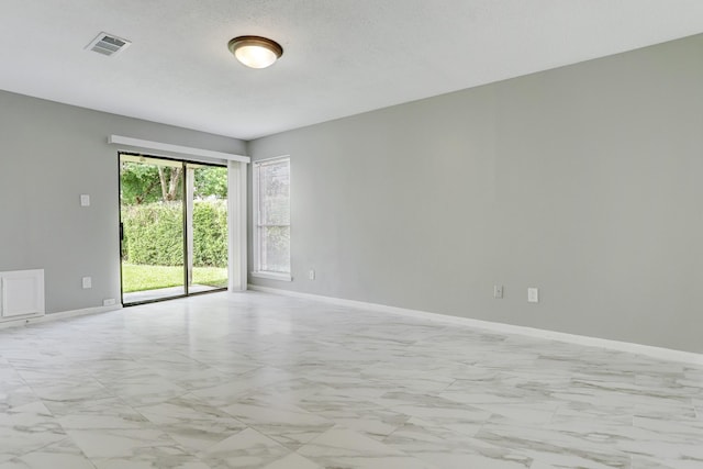 unfurnished room with a textured ceiling