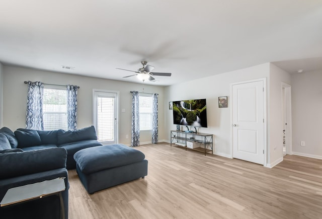 living room featuring plenty of natural light, ceiling fan, and light hardwood / wood-style flooring