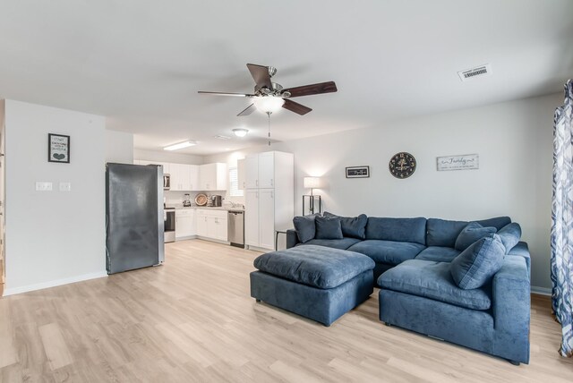 living room with ceiling fan and light hardwood / wood-style floors