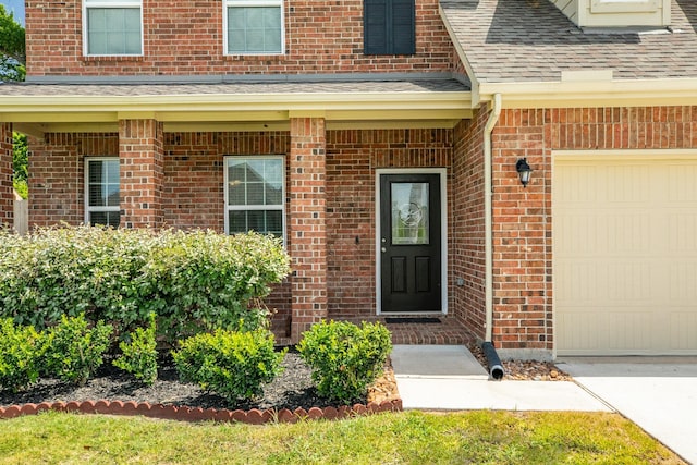 doorway to property with a garage and covered porch