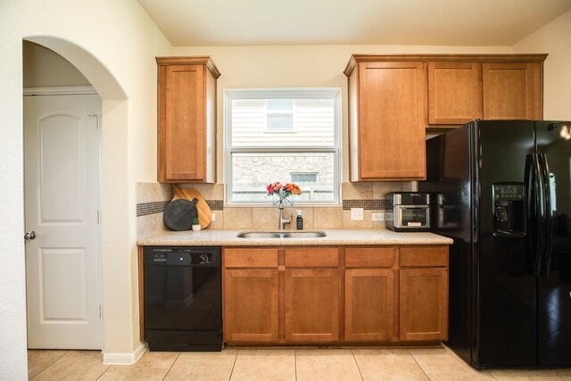 kitchen with light tile patterned flooring, sink, decorative backsplash, and black appliances