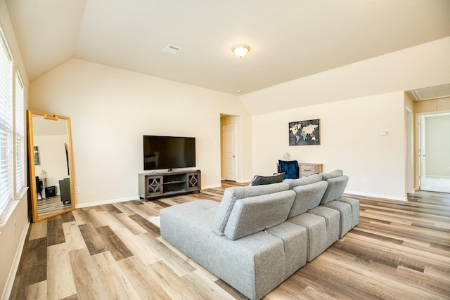 living room with vaulted ceiling and light hardwood / wood-style floors