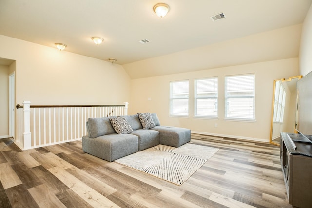 living room with vaulted ceiling and light hardwood / wood-style flooring