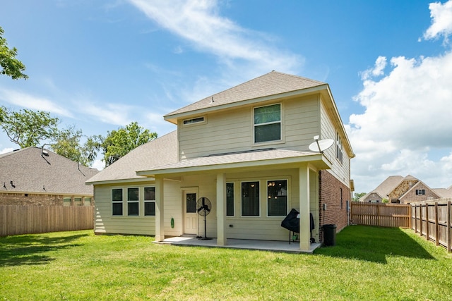 rear view of property featuring a lawn and a patio