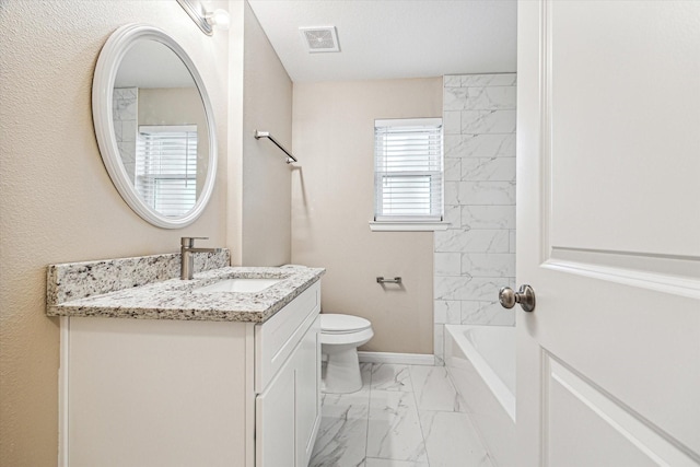 full bathroom with vanity, tiled shower / bath, and toilet