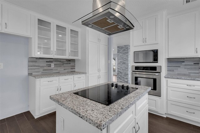 kitchen with white cabinetry, built in microwave, island range hood, black electric cooktop, and oven