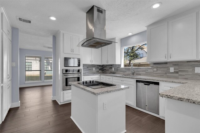 kitchen featuring island range hood, stainless steel appliances, white cabinets, and a kitchen island