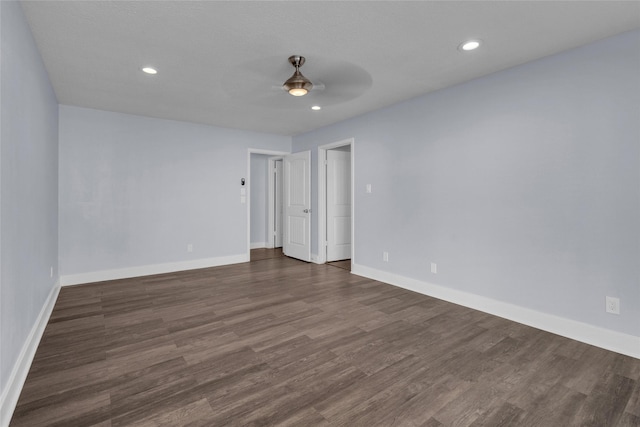 spare room with dark wood-type flooring and ceiling fan