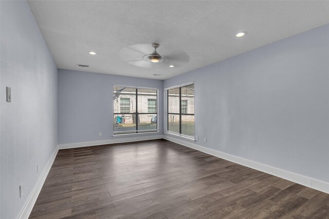 empty room with ceiling fan, dark hardwood / wood-style floors, and a textured ceiling